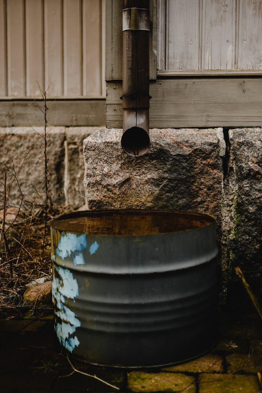 A metal downspout running down the outside wall of a house