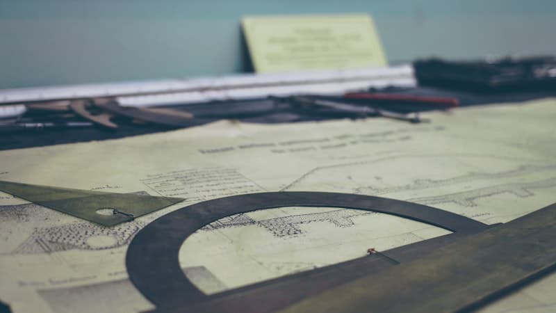Technical drawings and drafting tools laid out on a desk