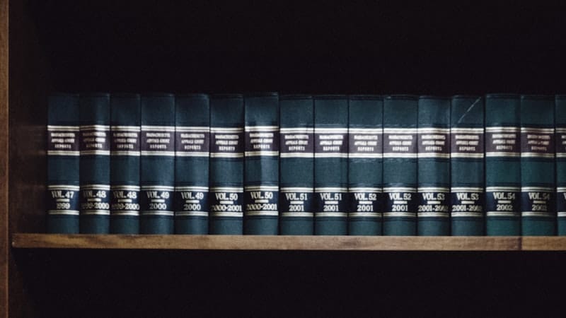 Row of bound legal volumes on a dark shelf