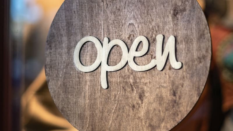 Round wooden sign hanging beside a window