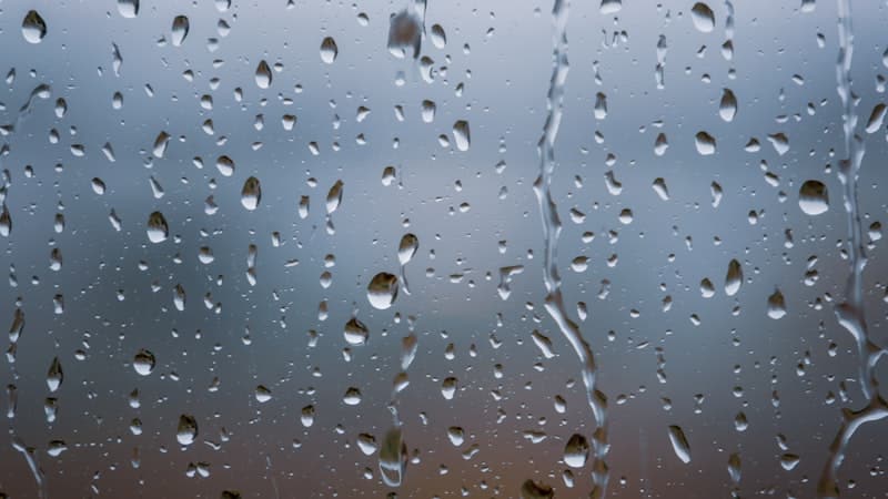 Rain drops running down a pane of glass