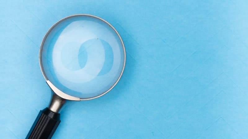 Magnifying glass lying on a plain blue surface