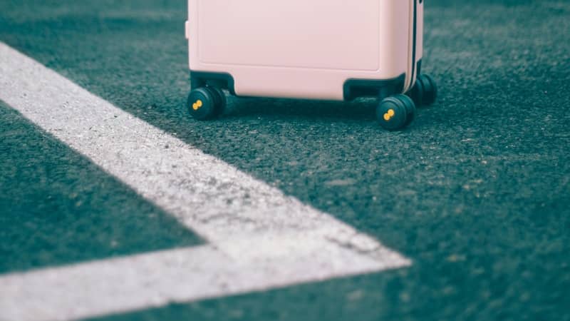 Wheeled suitcase standing on a painted road marking